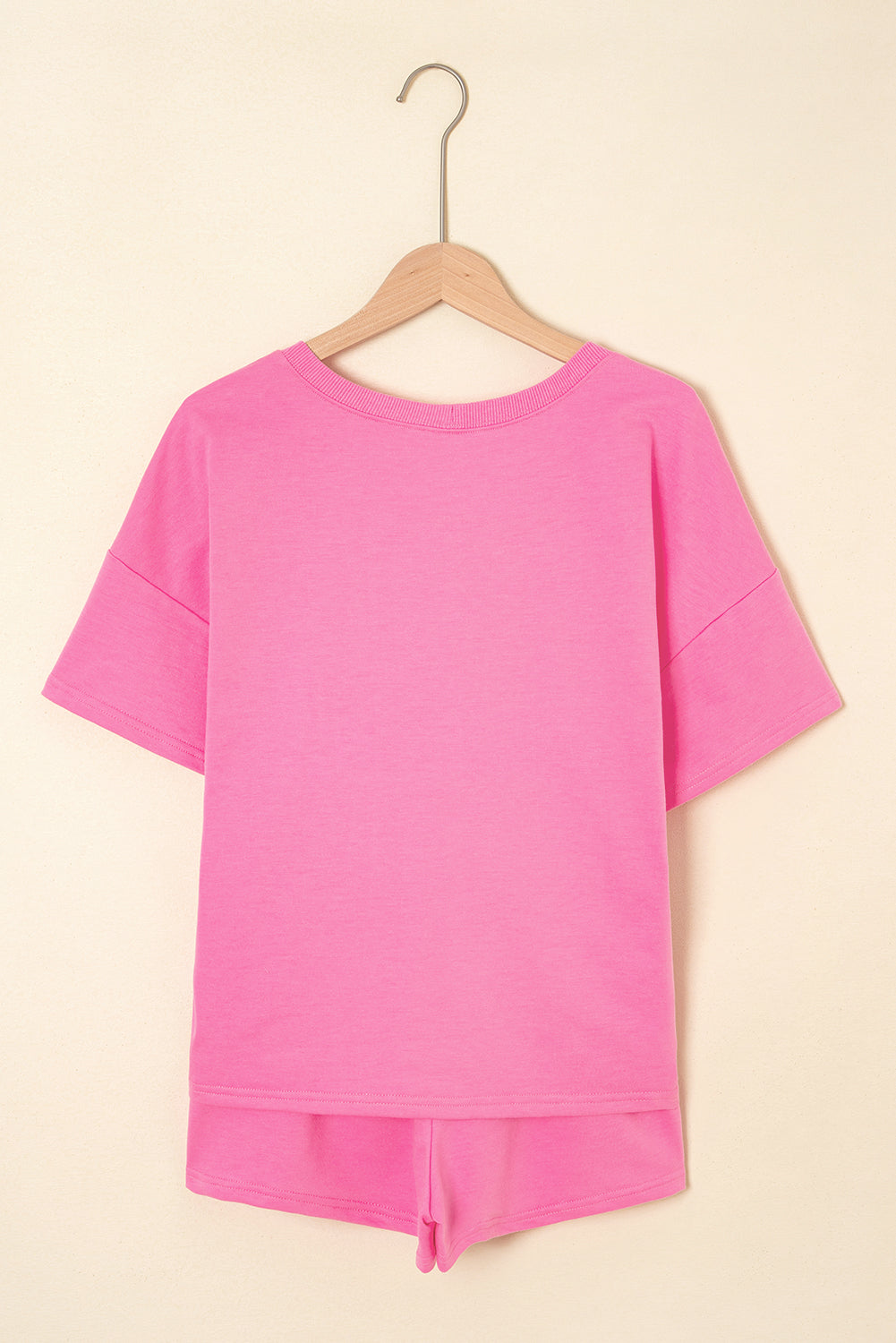 Pink top and shorts set on a beige background