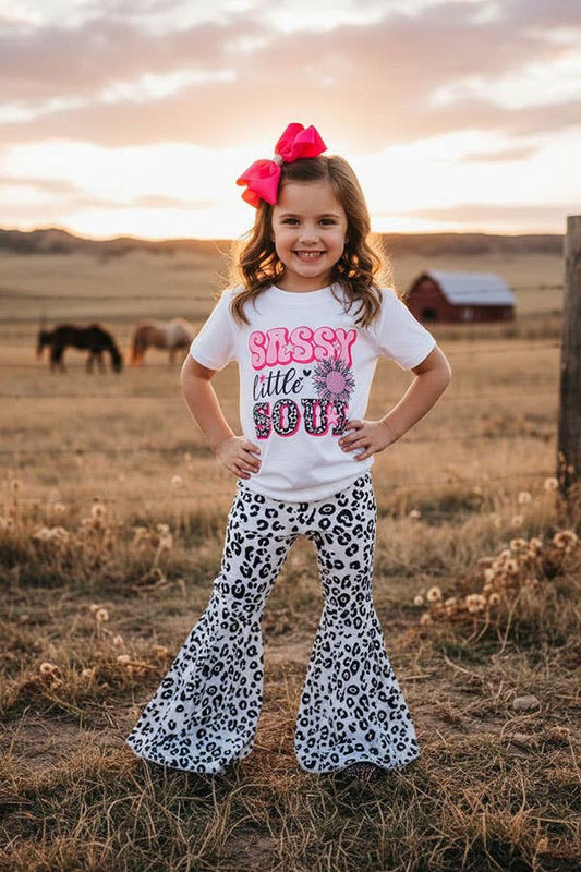 Young girl in a field wearing a 'Sassy Little Soul' shirt and leopard print pants.