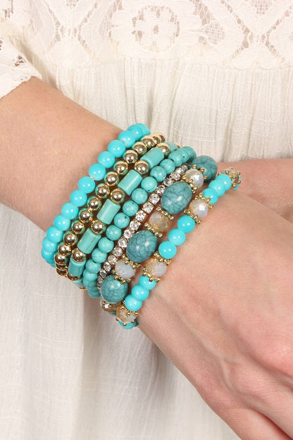 Turquoise beaded bracelet on a wrist with a white lace background