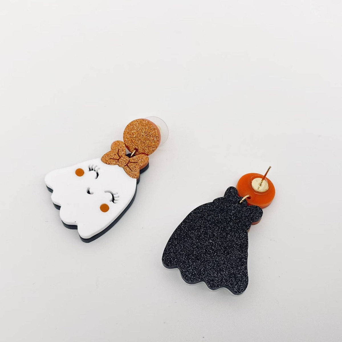 Pair of ghost and black cat earrings on a white background