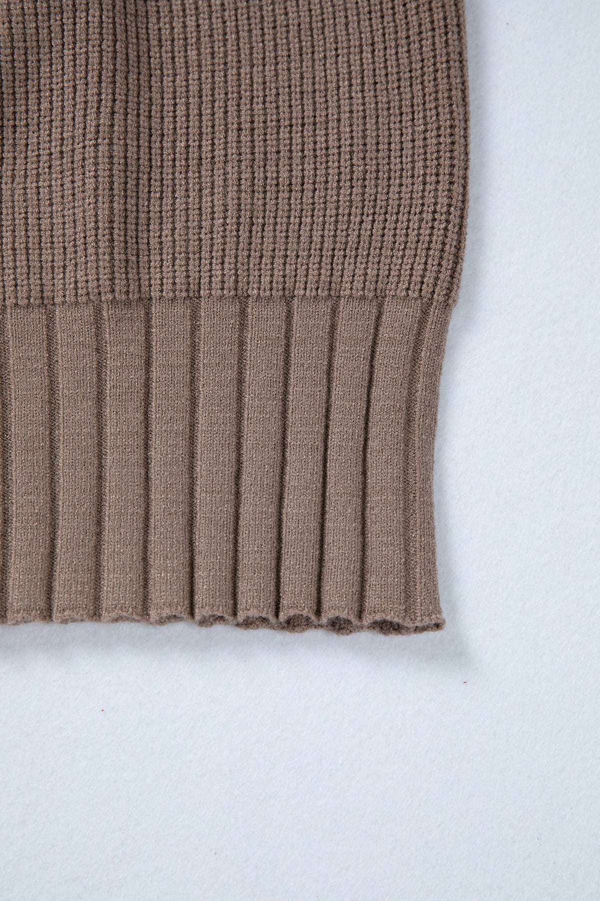 Brown knitted sweater sleeve on a white background