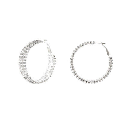 Pair of silver hoop earrings with clear gemstones on a white background