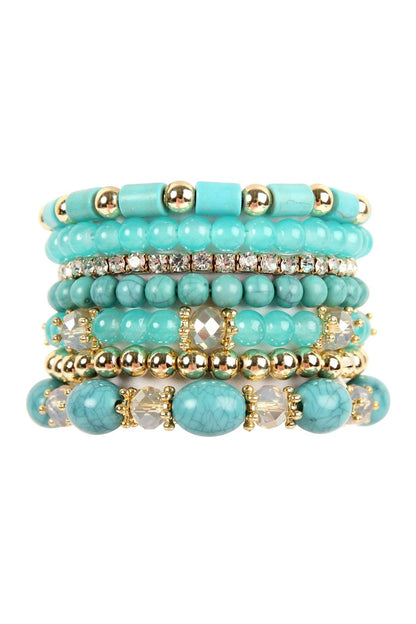 Stack of turquoise beaded bracelets with gold accents on a white background