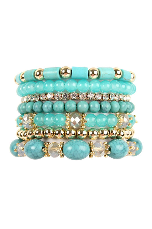 Stack of turquoise beaded bracelets with gold accents on a white background