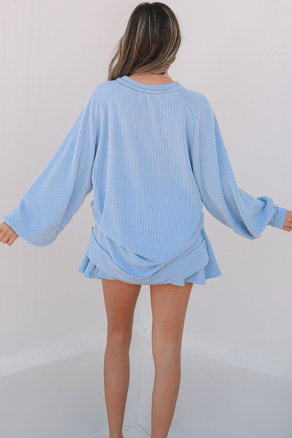 Light blue ribbed sweater and skirt set on a plain background