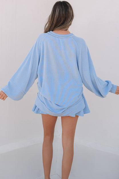 Light blue ribbed sweater and skirt set on a plain background