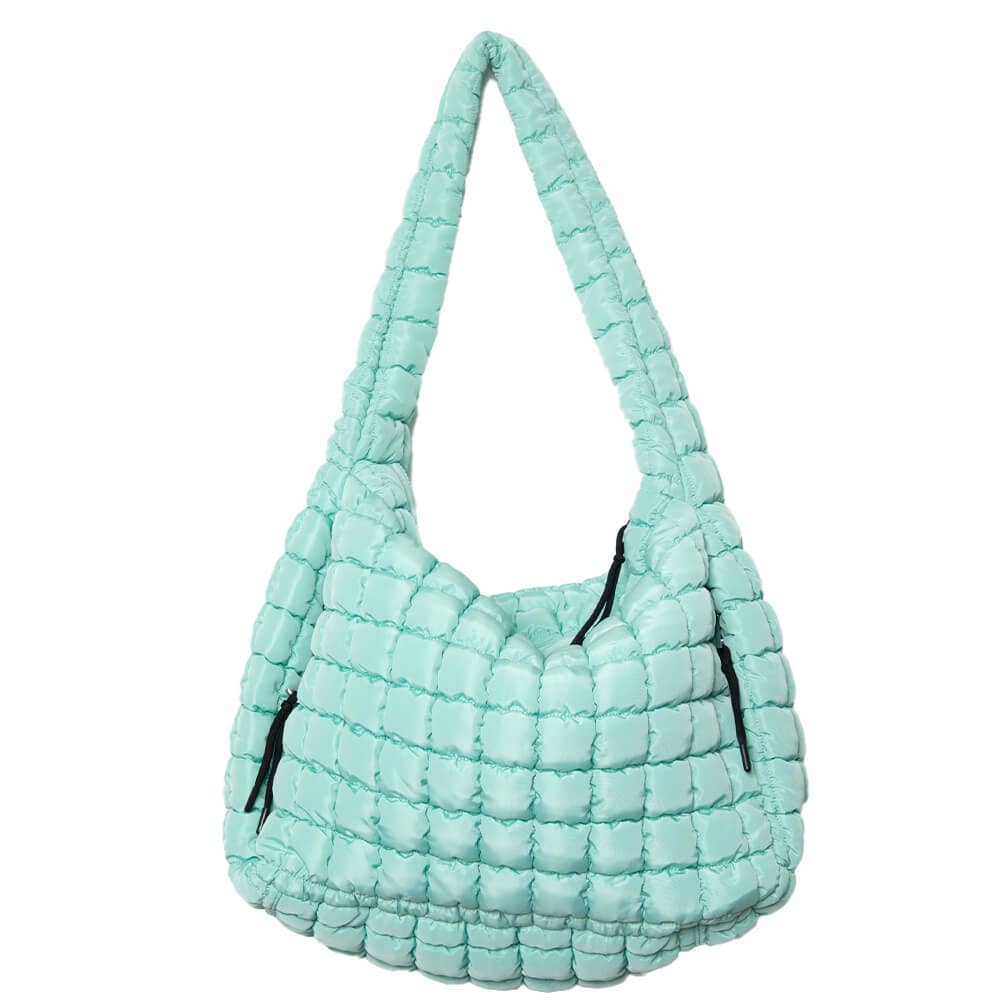 Light blue quilted handbag with black zippers on a white background