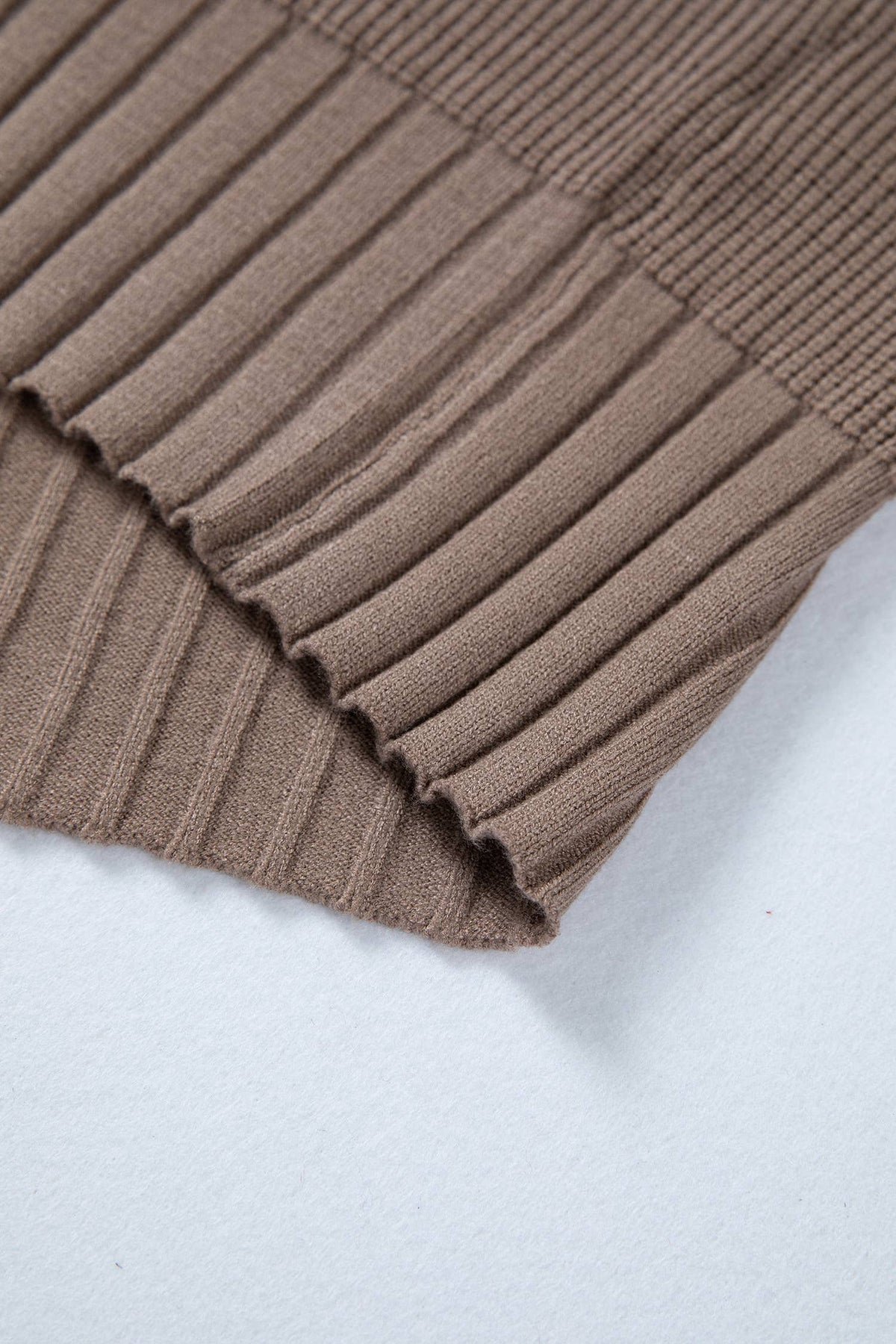 Close-up of a brown ribbed fabric on a light gray background