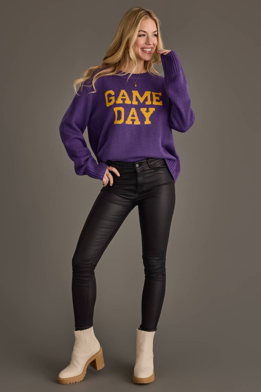 Purple and gold football game day sweater styled with black pants