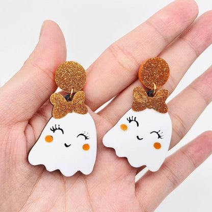 ghost-shaped earrings with bow details on a white background