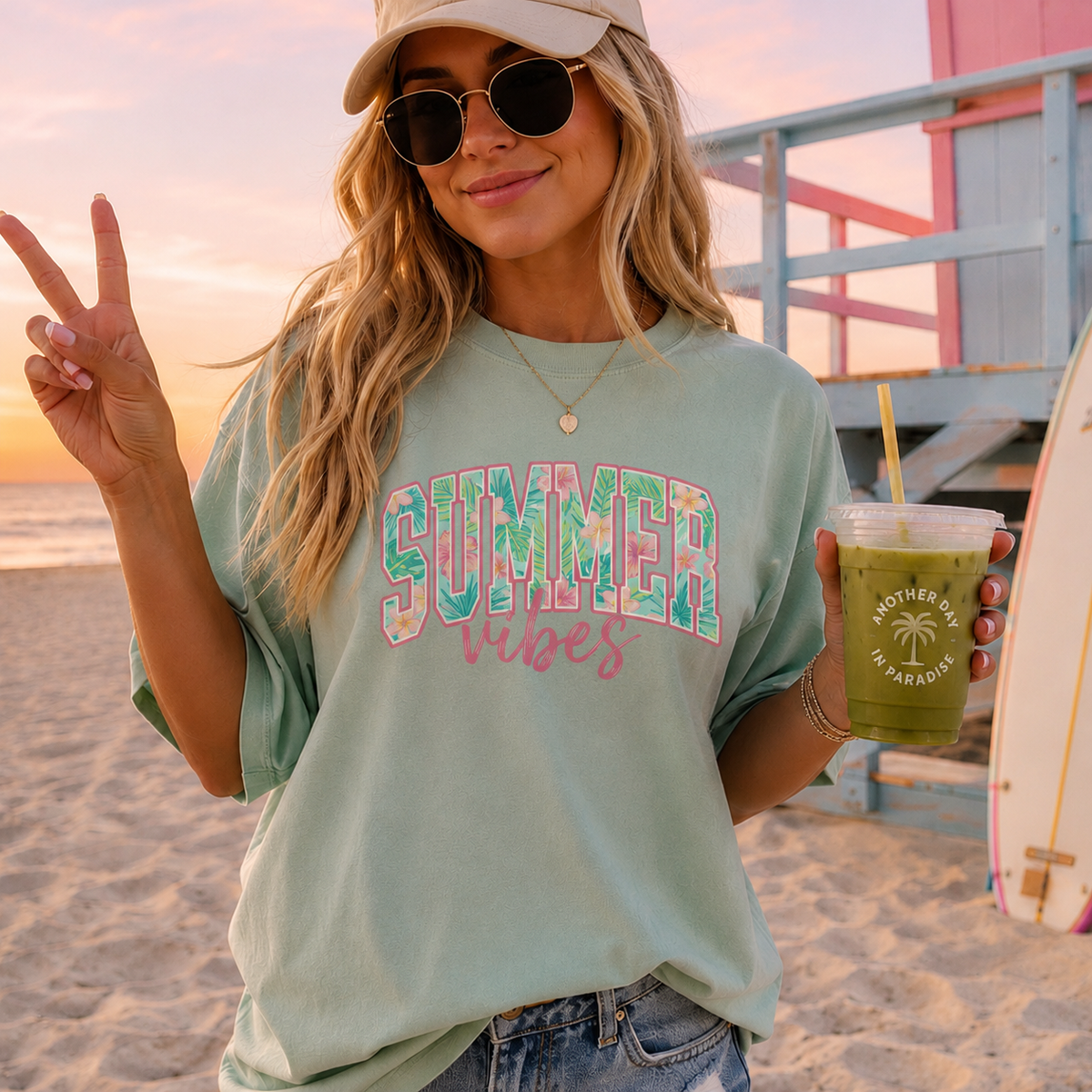 Woman on a beach wearing a 'Summer vibes' t-shirt and holding a drink.