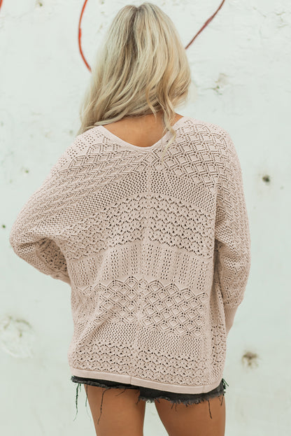 Person wearing a beige lace sweater against a light background