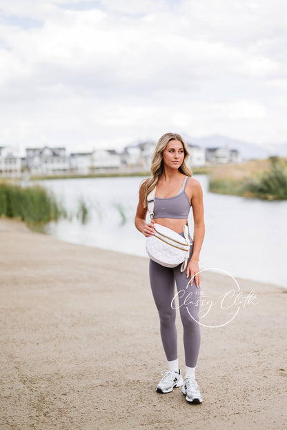 Woman in athletic wear standing by a lake with 'Classey Cloe' branding.