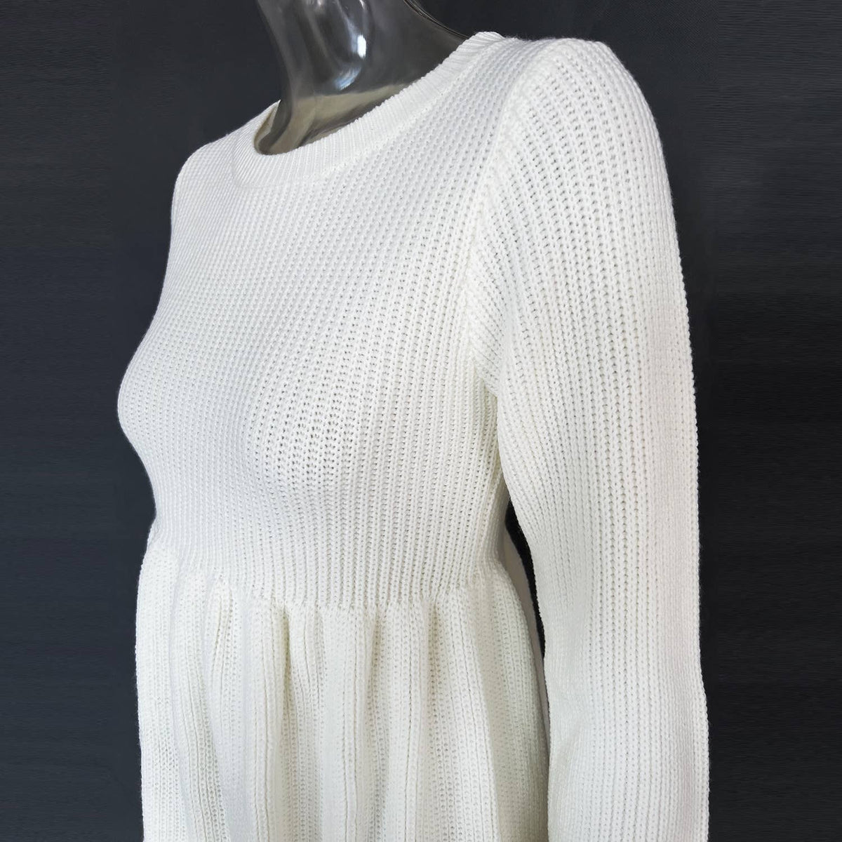 White knit dress on a mannequin against a dark background
