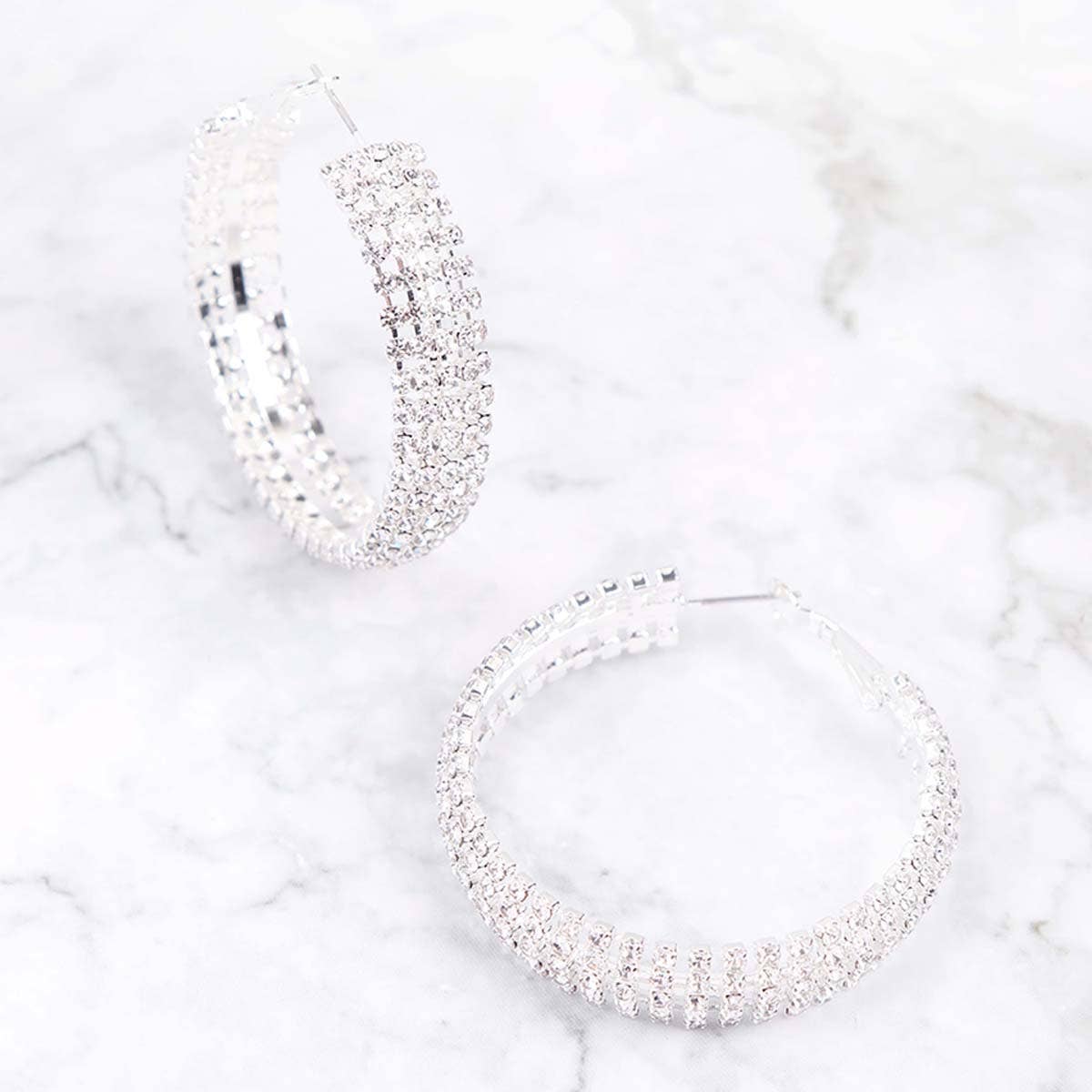 Silver hoop earrings on a marble surface