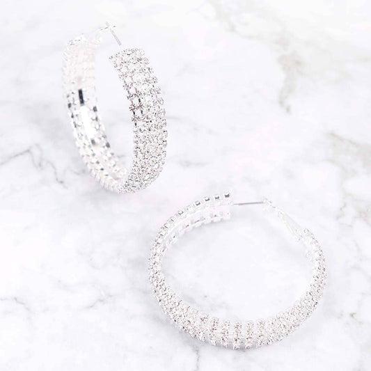 Silver hoop earrings on a marble surface