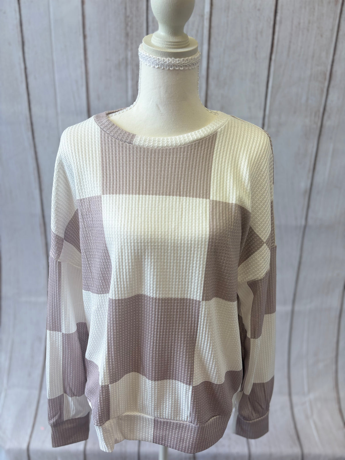Mannequin wearing a striped sweater with a neutral background