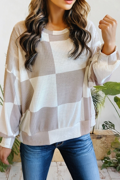Person wearing a plaid sweater and blue jeans with a white background