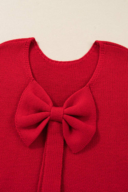 Red sweater with a large bow detail on a beige background