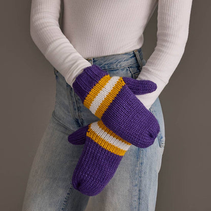 Purple, gold and white striped knit mittens worn with a white sweater and jeans