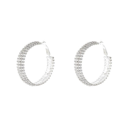 Pair of silver hoop earrings with clear stones on a white background