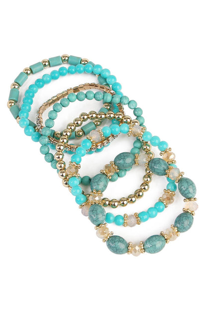 Set of turquoise beaded bracelets with gold accents on a white background