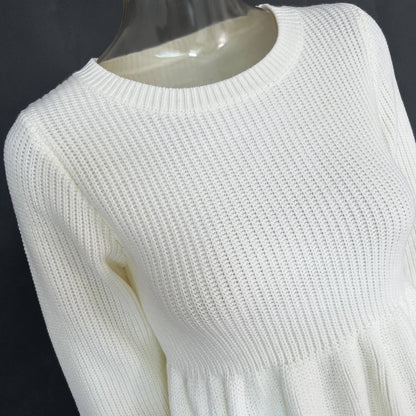 White knitted sweater on a mannequin against a dark background