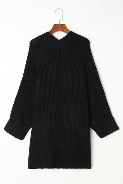 Black sweater on a hanger against a white background