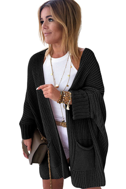 Woman wearing a black cardigan over a white top on a white background