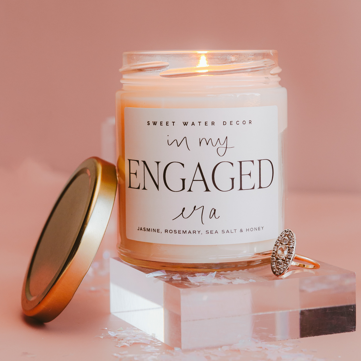 Candle labeled 'In My Engaged Era' with a ring on a pink background