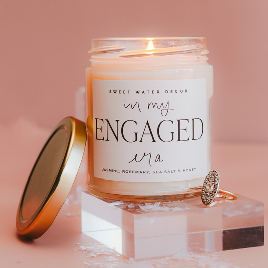 Candle labeled 'In My Engaged Era' with a ring on a pink background