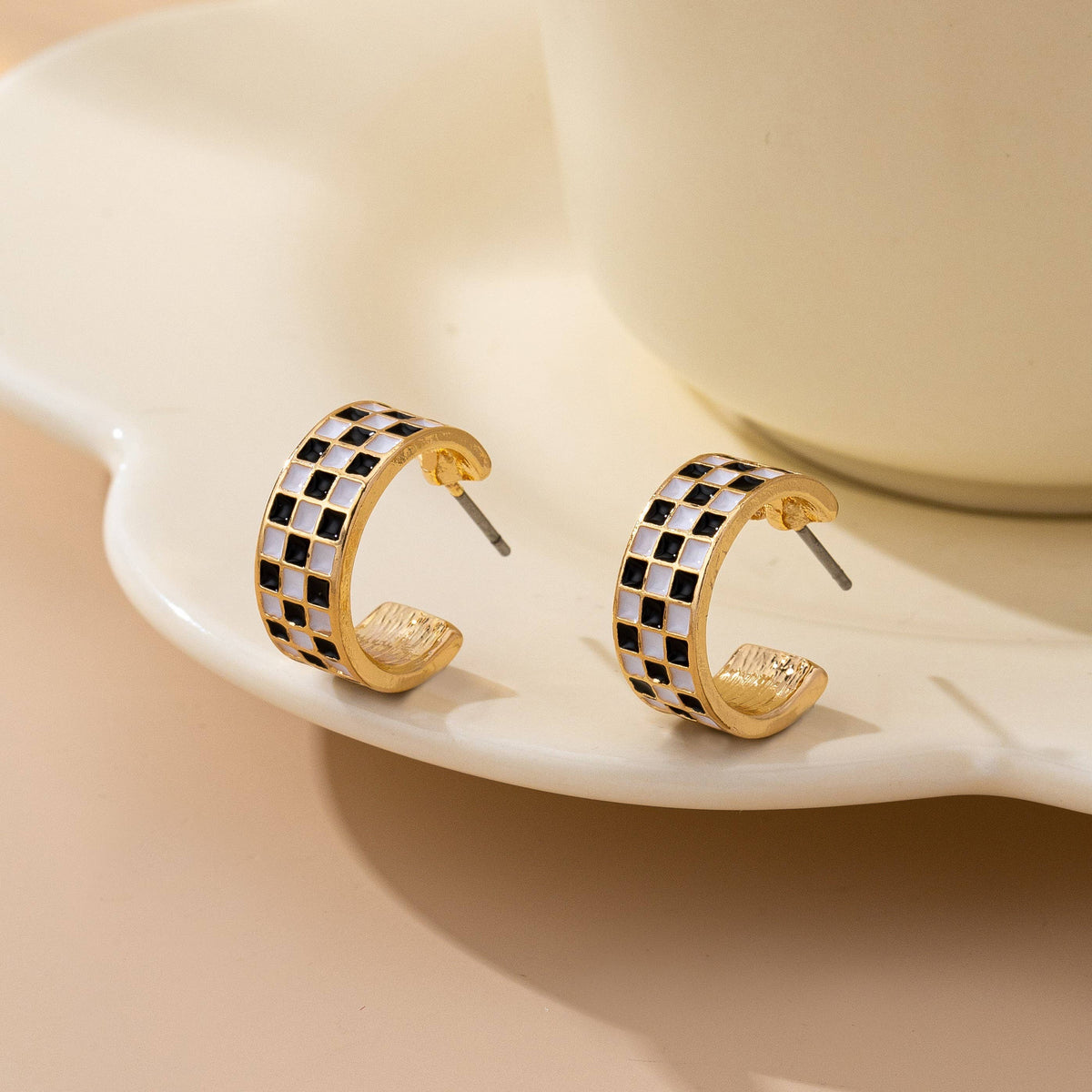 Pair of Sloane gold-tone huggie hoop earrings with black-and-white checkerboard enamel

