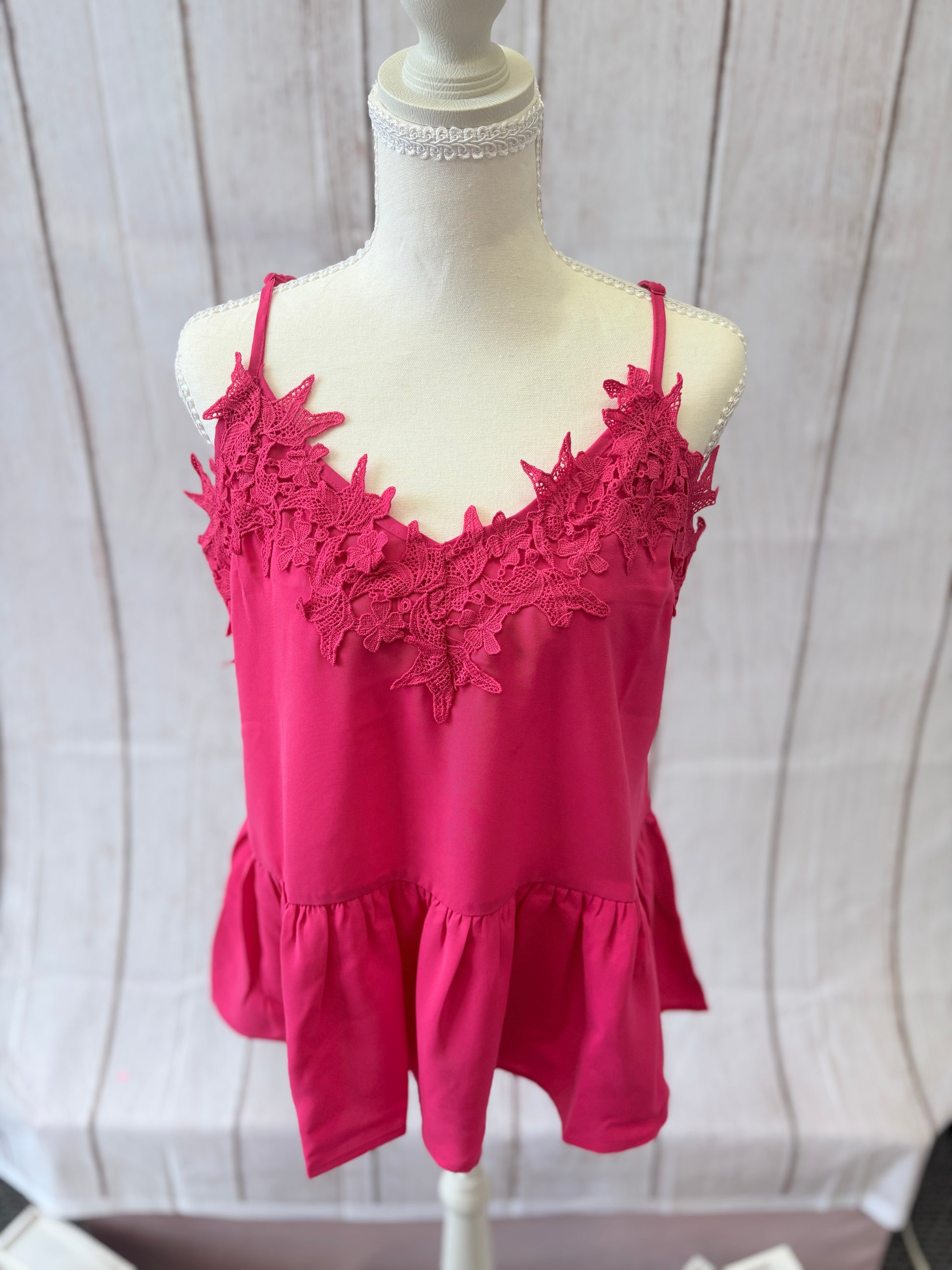 Pink lace top on a mannequin against a white background