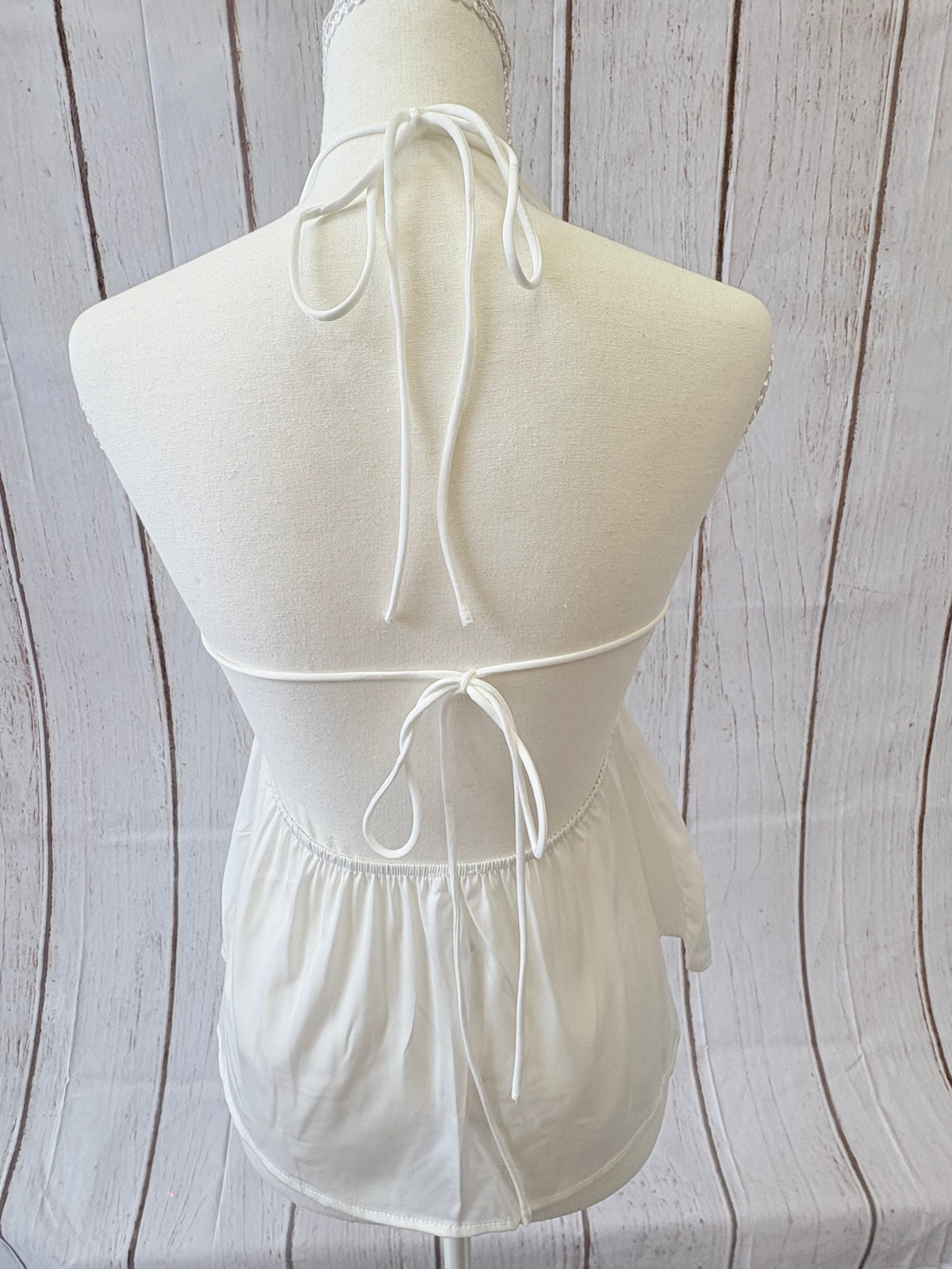White strapless dress with a large bow on a wooden surface